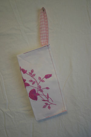 Clutch hanging on wall with matching pink gingham ribbon handle